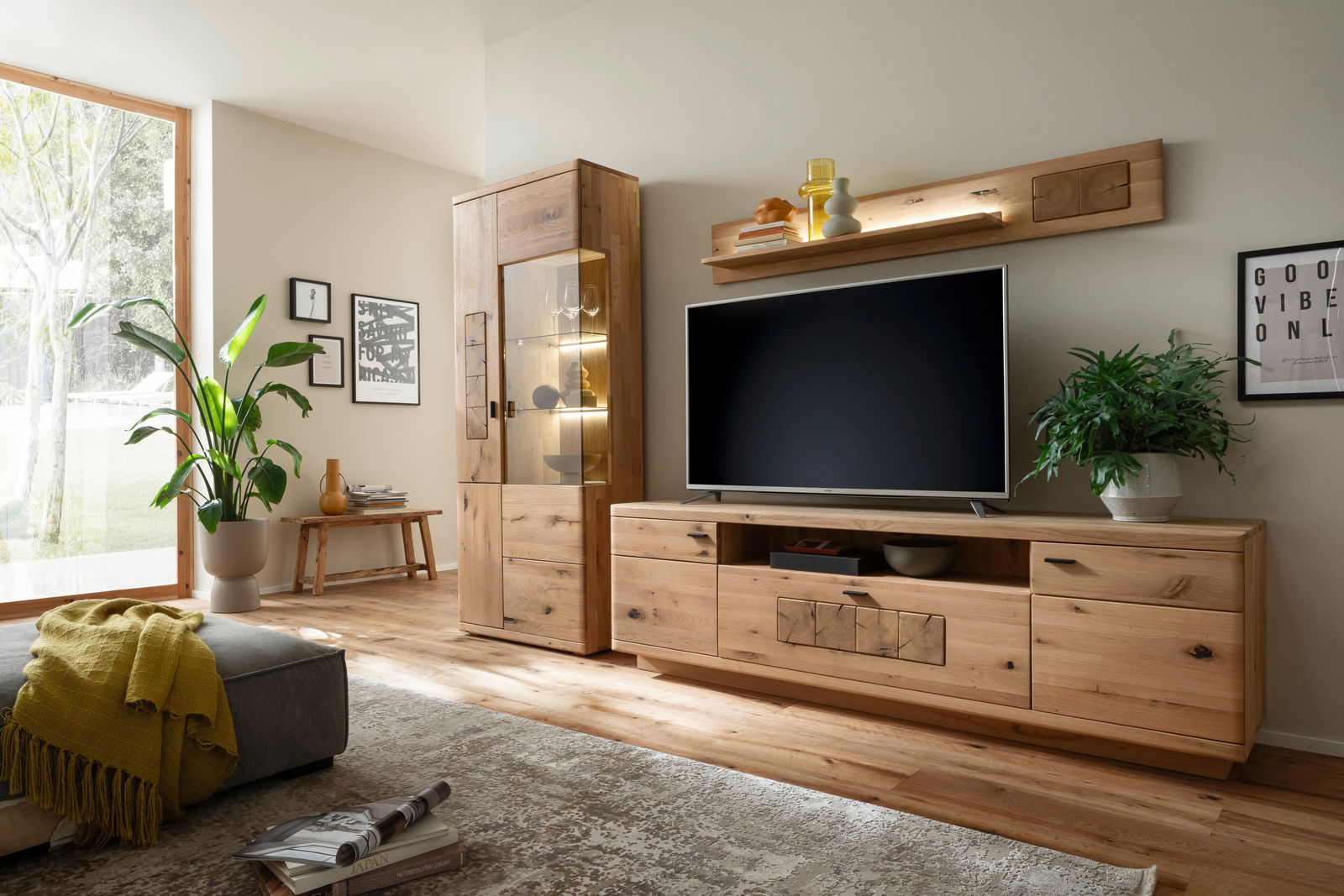 Moderne Wohnzimmer-Wandkombination aus Holz mit TV-Schrank, Vitrine und Regal, seitliche Perspektive.