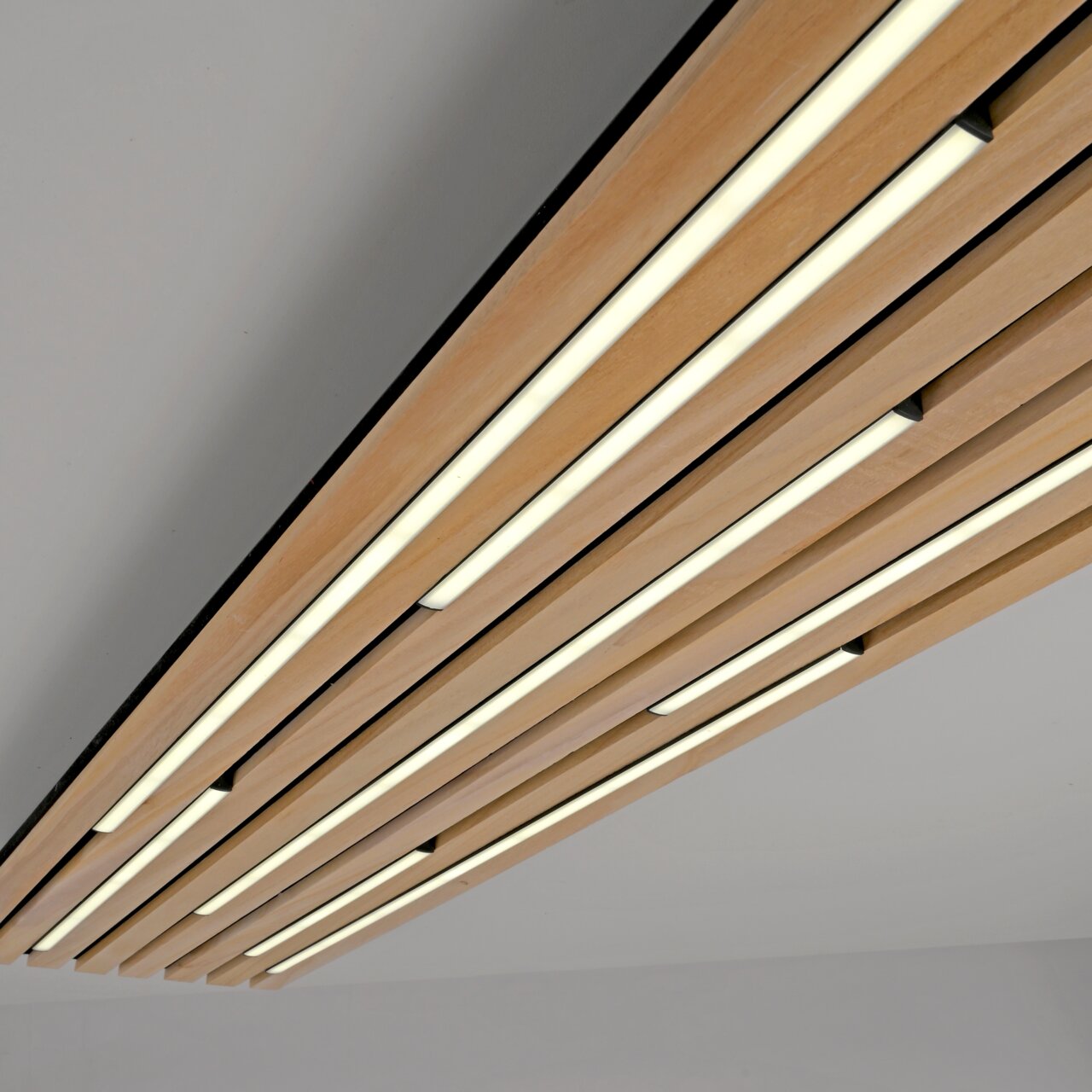 Moderne LED-Deckenleuchte mit Holzlamellen, von unten betrachtet.