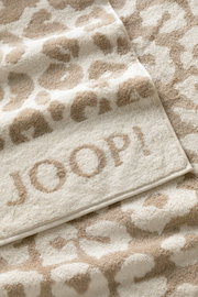Beiges Saunatuch mit Leopardenmuster und eingewebtem Schriftzug 'JOOP!' in Nahaufnahme