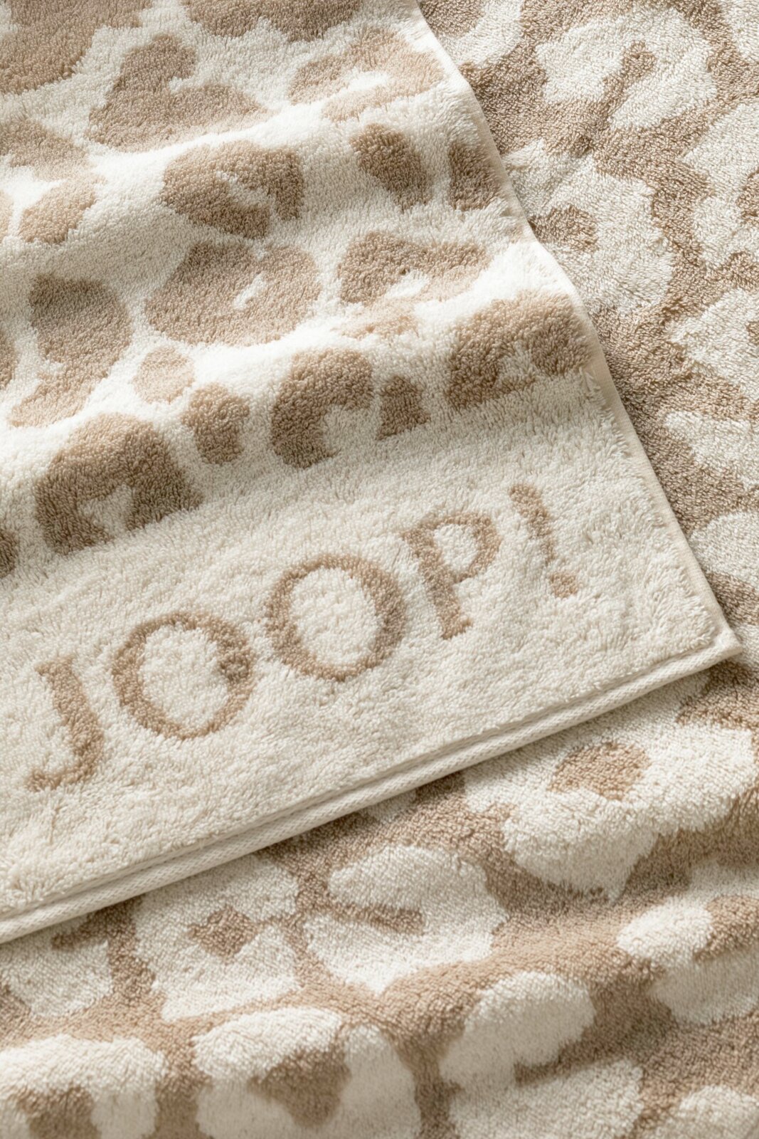 Beige saunadoek met luipaardprint en ingeweven 'JOOP!'-logo in close-up