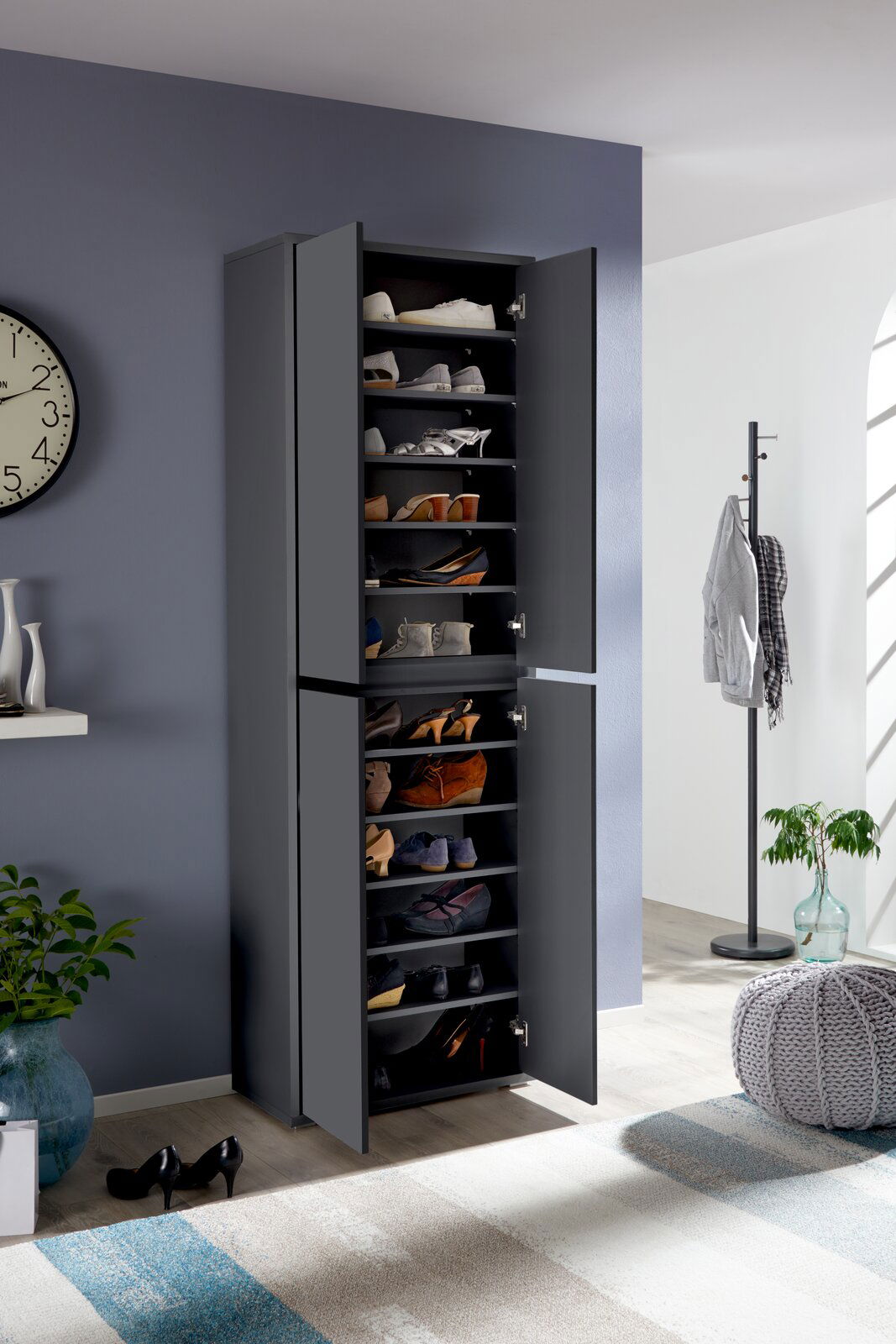 XXL-Schuh- und Mehrzweckschrank in dunklem Grau, gefüllt mit verschiedenen Schuhen, in einem modernen Raum mit geöffneter Tür, seitliche Perspektive.