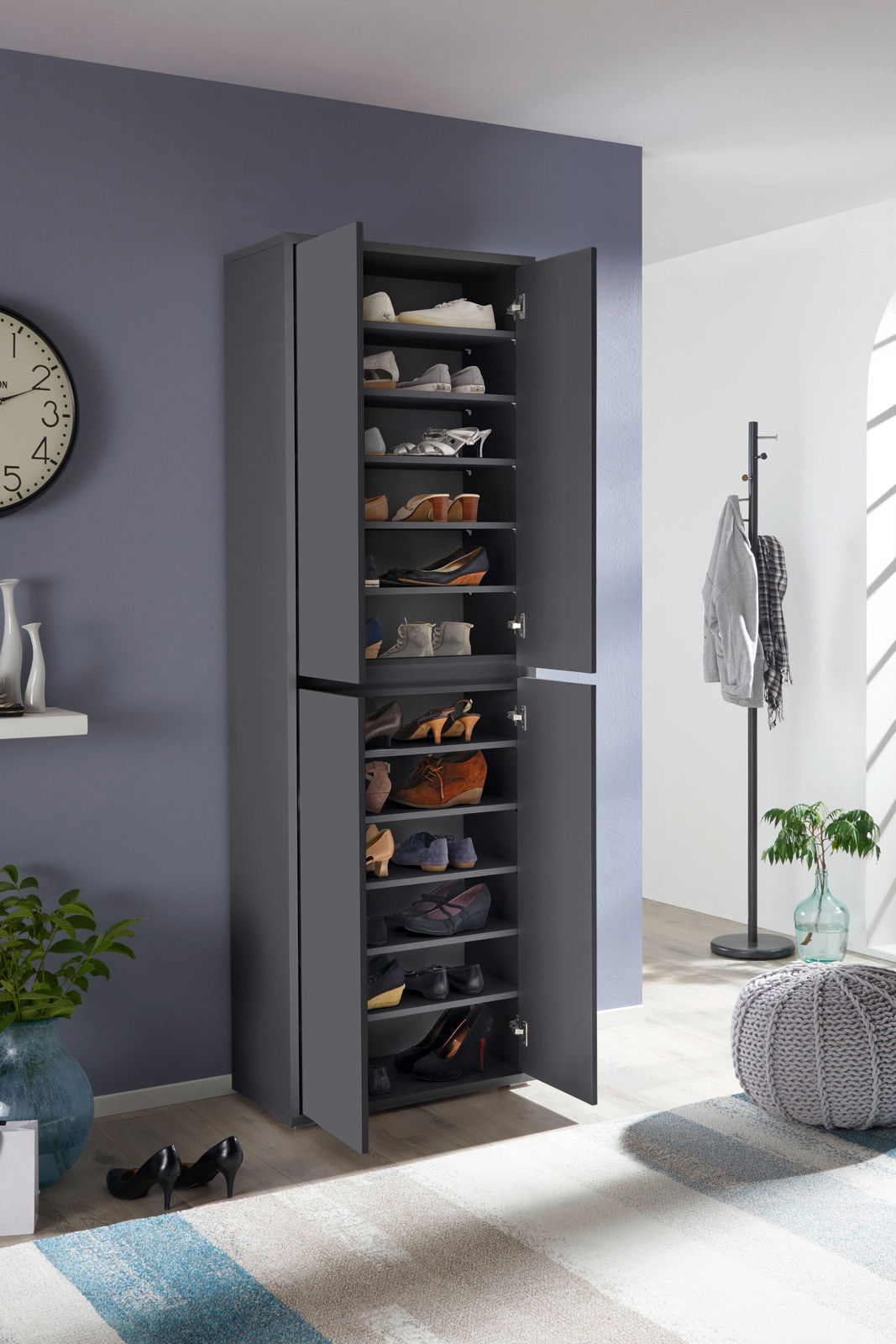 XXL-Schuh- und Mehrzweckschrank in dunklem Grau, gefüllt mit verschiedenen Schuhen, in einem modernen Raum mit geöffneter Tür, seitliche Perspektive.