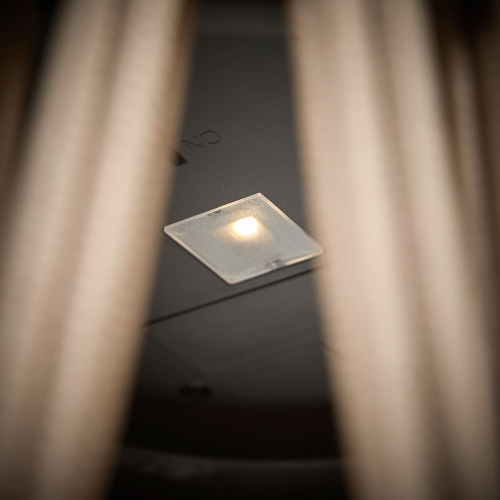 Nahaufnahme einer Solarlampe mit leuchtender LED, von unten betrachtet.