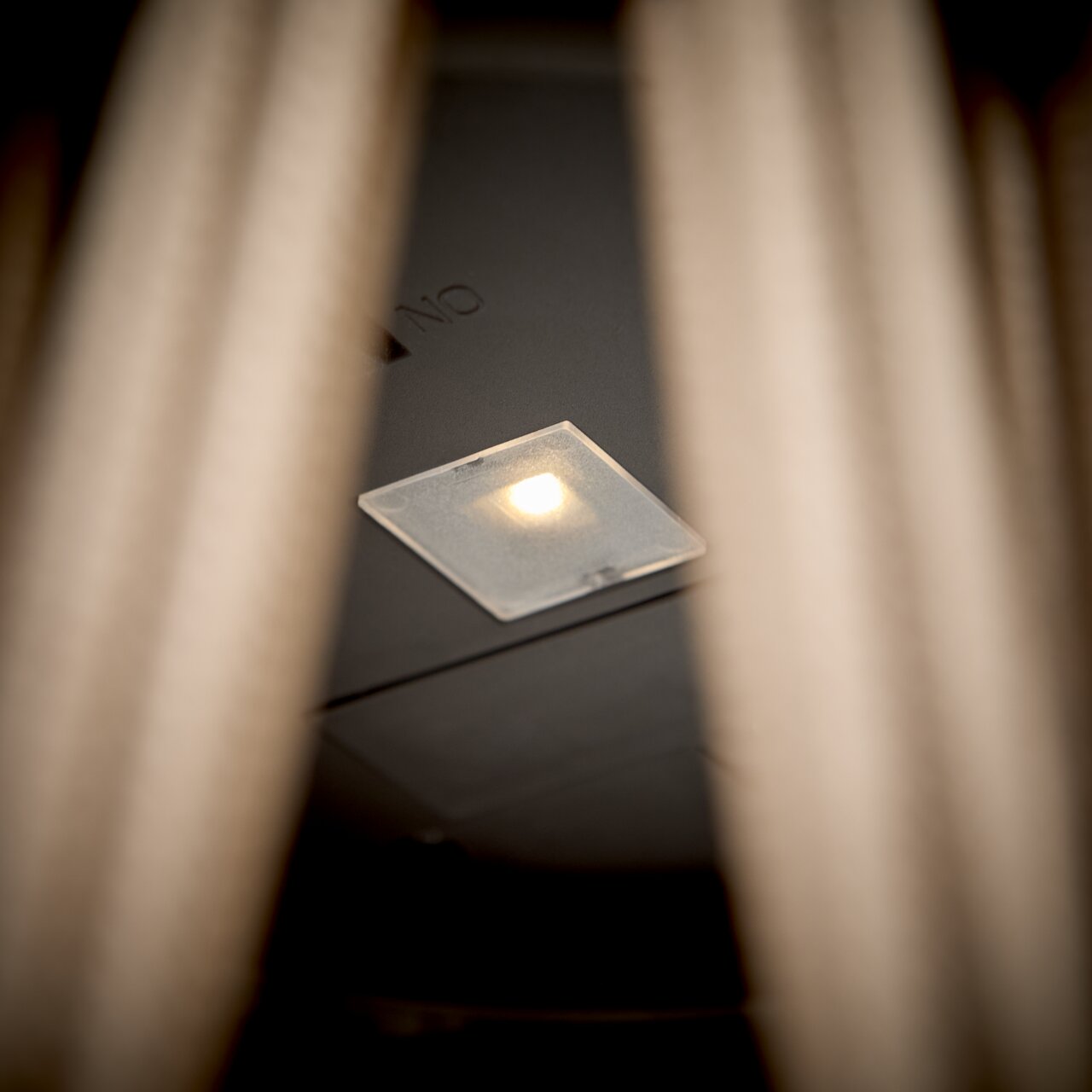 Nahaufnahme einer Solarlampe mit leuchtender LED, von unten betrachtet.