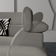 Graues Ecksofa mit verstellbarer Kopfstütze, seitliche Perspektive, dekoratives Kissen mit schwarz-weißem Muster.