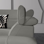 Graues Ecksofa mit verstellbarer Kopfstütze, seitliche Perspektive, dekoratives Kissen mit schwarz-weißem Muster.