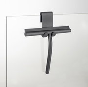 Moderner Badezimmerwischer aus Silikon in dunkler Farbe, an einer Glaswand hängend, seitliche Perspektive.