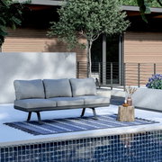 Modern driezitslounge-element in een stijlvolle buitenruimte, gezien vanaf de zijkant.