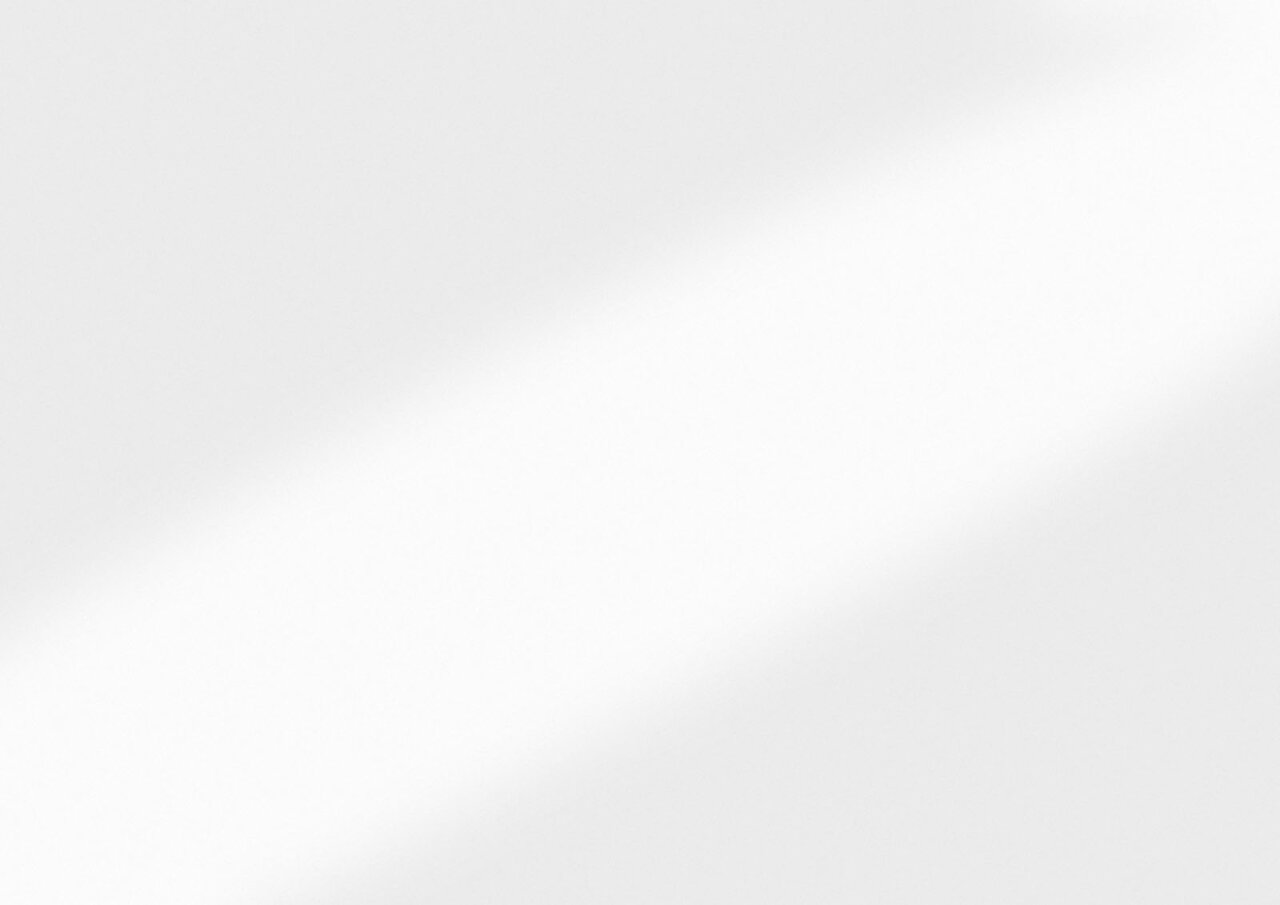 Nahaufnahme einer weißen, glatten Oberfläche mit leichtem Schattenverlauf.