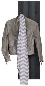 Garderobenpaneel in schwarzer Holzoptik mit einer grauen Lederjacke und einem gestreiften Schal, frontal betrachtet.