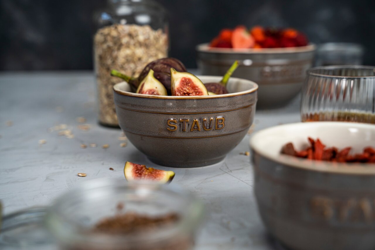 Staub Set van 4 lepels Graues Schüsselset von STAUB mit Feigen gefüllt, aus seitlicher Perspektive fotografiert.