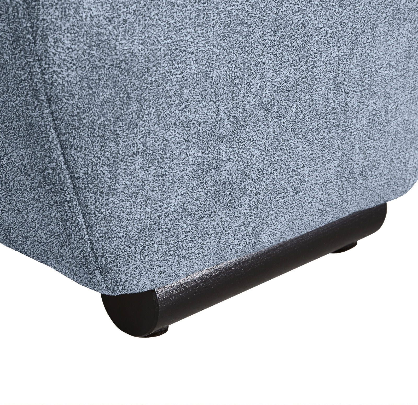 Nahaufnahme der unteren Ecke eines Big-Sofas mit grauem Stoffbezug und dunklem Holzfuß, seitliche Perspektive.