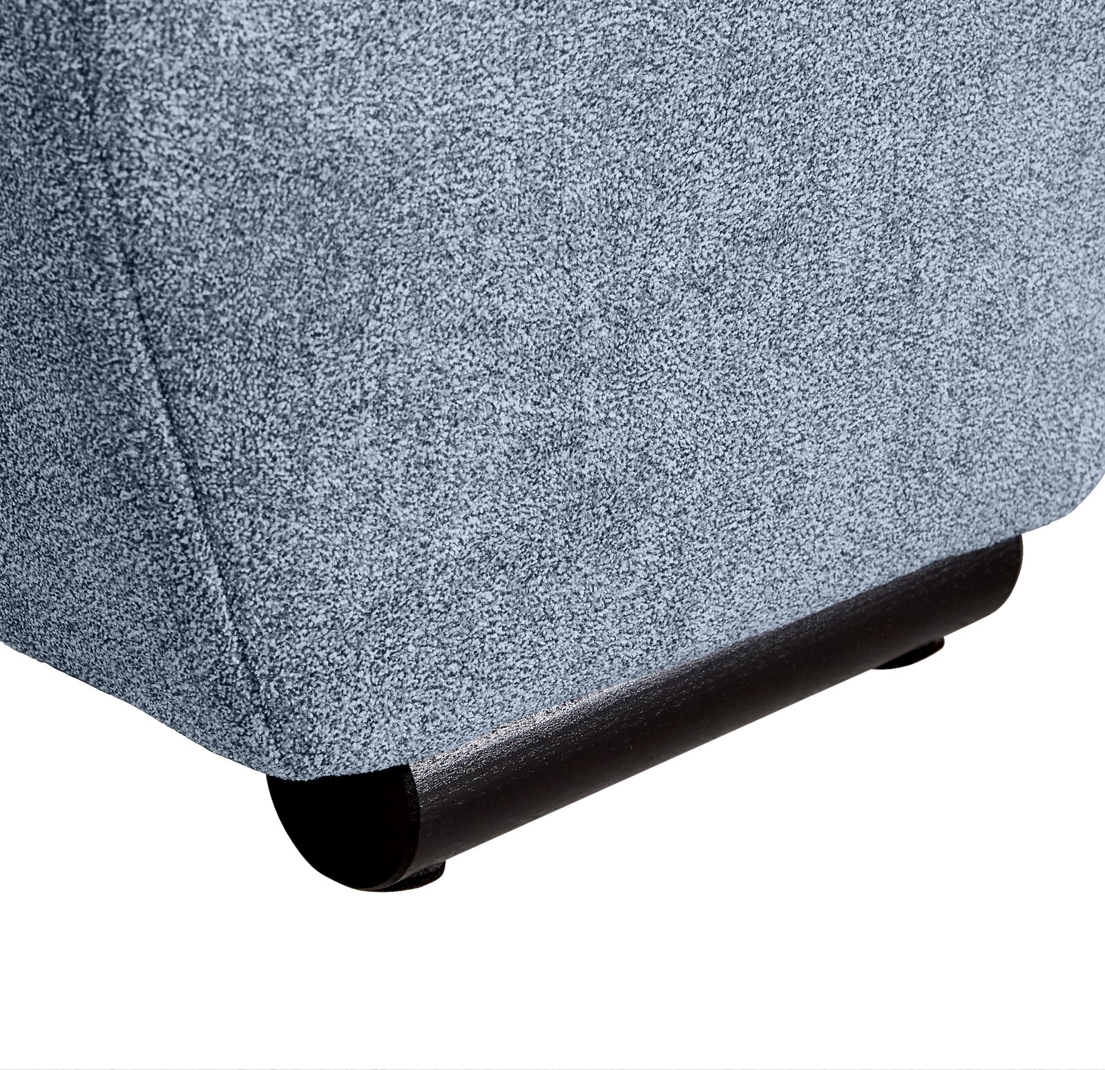 Nahaufnahme der unteren Ecke eines Big-Sofas mit grauem Stoffbezug und dunklem Holzfuß, seitliche Perspektive.