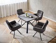 Vier graue Armlehnstühle um einen quadratischen Tisch in einem modernen Esszimmer, aus der Vogelperspektive fotografiert.