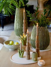 Eine cremefarbene Schale mit einem Durchmesser von 40 cm und einer Höhe von 1,5 cm, gefüllt mit grünen Äpfeln, auf einem Holztisch. Die Perspektive ist von oben leicht seitlich.