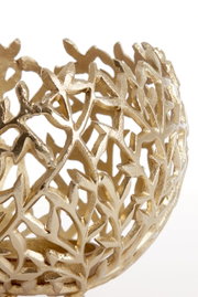 Close-up van een gouden, filigraan theelichthouder met een bladachtig patroon, gezien vanaf de zijkant.