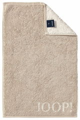 Beiges Gästetuch mit eingewebtem 'JOOP!' Logo, von oben fotografiert, mit umgeschlagener Ecke, die das Etikett zeigt.
