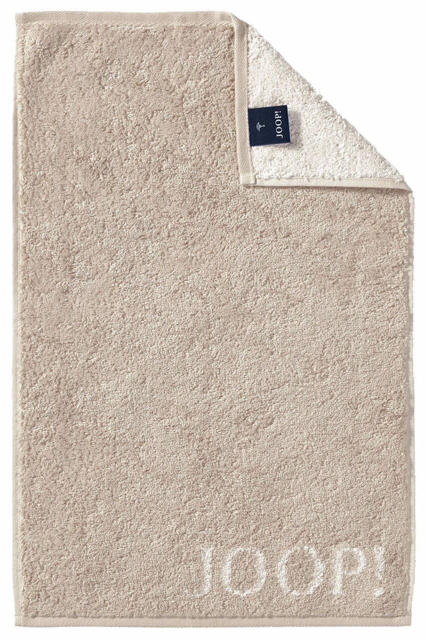 Beiges Gästetuch mit eingewebtem 'JOOP!' Logo, von oben fotografiert, mit umgeschlagener Ecke, die das Etikett zeigt.