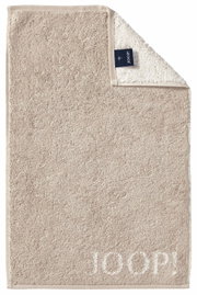 Beige gastendoekje met ingeweven 'JOOP!'-logo, van bovenaf gefotografeerd, met een omgeslagen hoekje waardoor het label zichtbaar is.