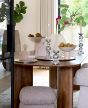 Elegante Vase in einem modernen Wohnambiente, frontal auf einem Tisch platziert, umgeben von dekorativen Elementen und Pflanzen.