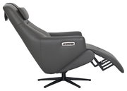 Seitliche Ansicht eines grauen Relaxsessels mit verstellbarer Rückenlehne und Fußstütze, auf einem drehbaren Standfuß.