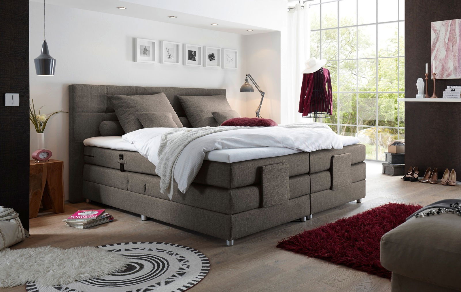 Modernes Boxspringbett in einem stilvoll eingerichteten Schlafzimmer, seitliche Perspektive