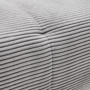 Nahaufnahme einer grauen, gerippten Stoffoberfläche eines Ecksofas aus der Perspektive von oben.