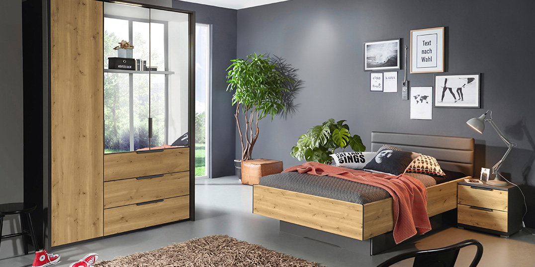 Modernes Schlafzimmer mit Holz-Möbeln, grauer Wand, Doppelbett, Kleiderschrank, Pflanzen und Wanddeko