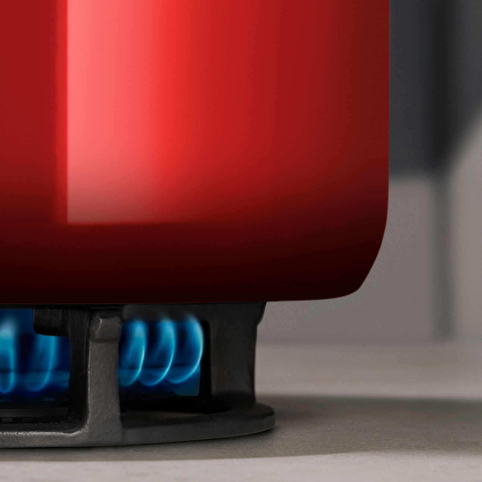 Roter Topf auf einem Gasherd, seitliche Perspektive