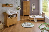 Komplettes Babyzimmer-Set mit Wickelkommode, Babybett, Kleiderschrank und Wandregal aus Holz, aus der Perspektive von vorne fotografiert.