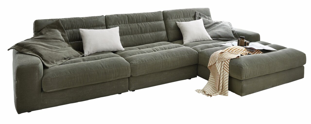 Große, moderne Longchairkombination in grauem Stoff mit Kissen und Decke, seitliche Perspektive.