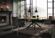 Moderner Esstisch mit Holzplatte und schwarzen Metallbeinen, umgeben von vier schwarzen Stühlen, in einem stilvollen Raum mit Kamin und Panoramafenster. Perspektive von der Seite.