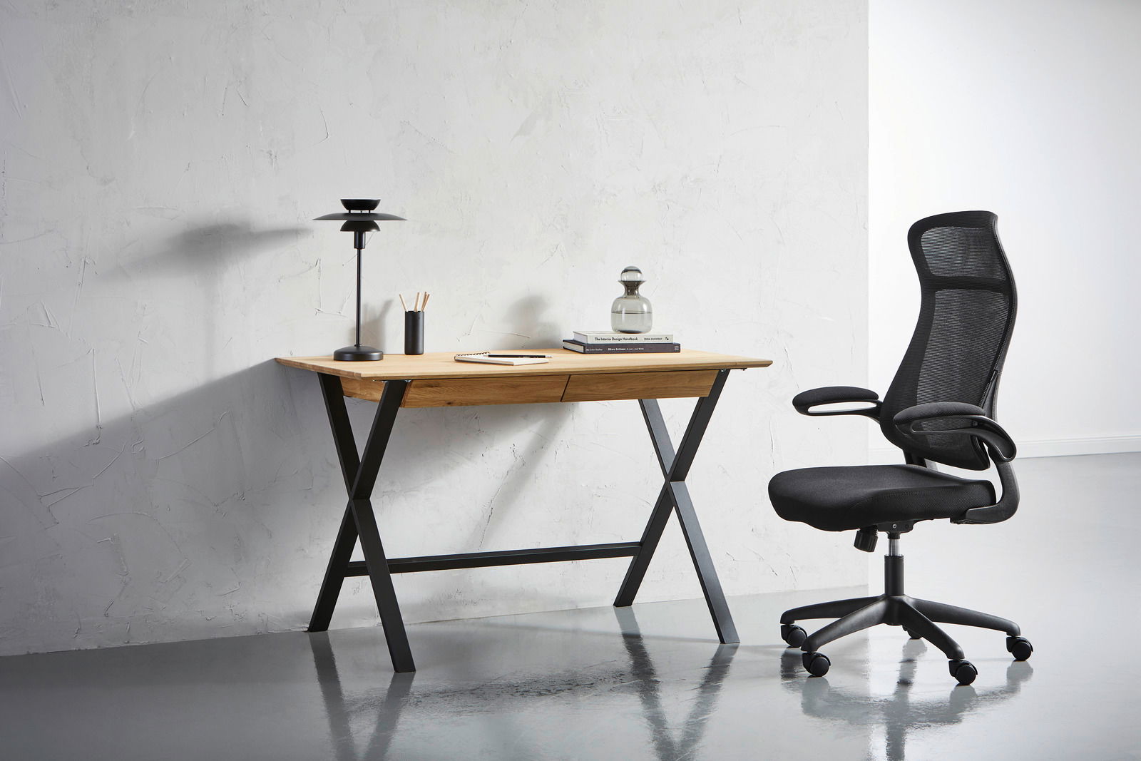 Linea Natura Schreibtisch BERN Moderner Schreibtisch mit Holzplatte und schwarzen Metallbeinen, seitliche Perspektive, mit Bürostuhl und Schreibtischlampe.