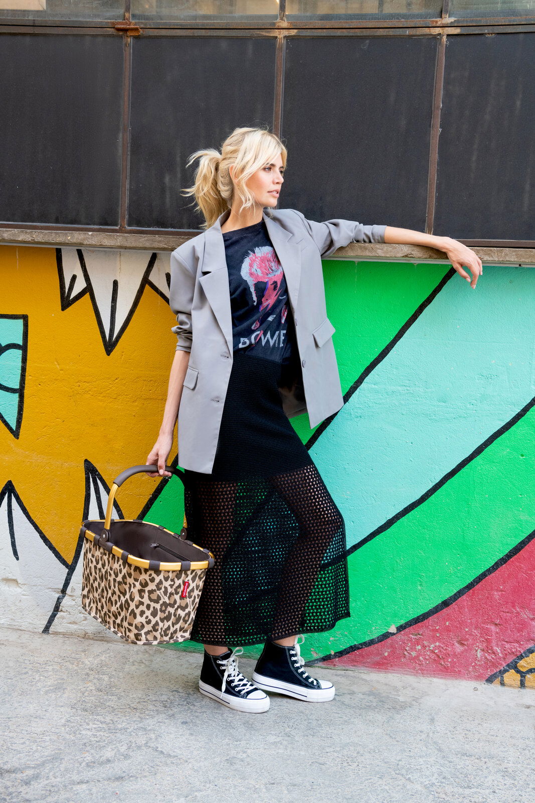 Frau in urbaner Umgebung mit einem Carrybag Frame Leo Macchiato in der Hand, seitliche Perspektive