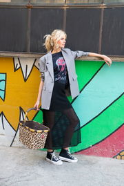 Frau in urbaner Umgebung mit einem Carrybag Frame Leo Macchiato in der Hand, seitliche Perspektive