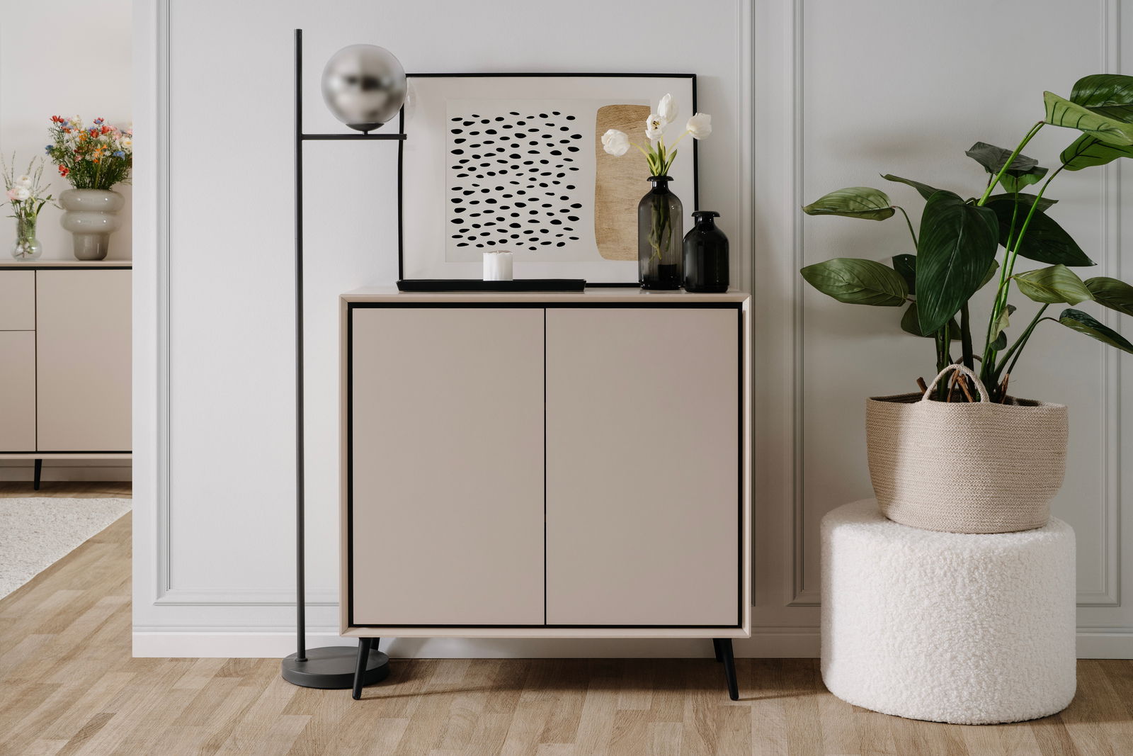 Modernes Sideboard in einem stilvollen Raum, frontal betrachtet, mit Dekorationen wie einer Lampe, Kunstwerk und Pflanzen.