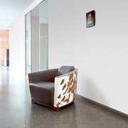 Moderner Sessel mit braunem Leder und Kuhfellmuster, seitliche Perspektive