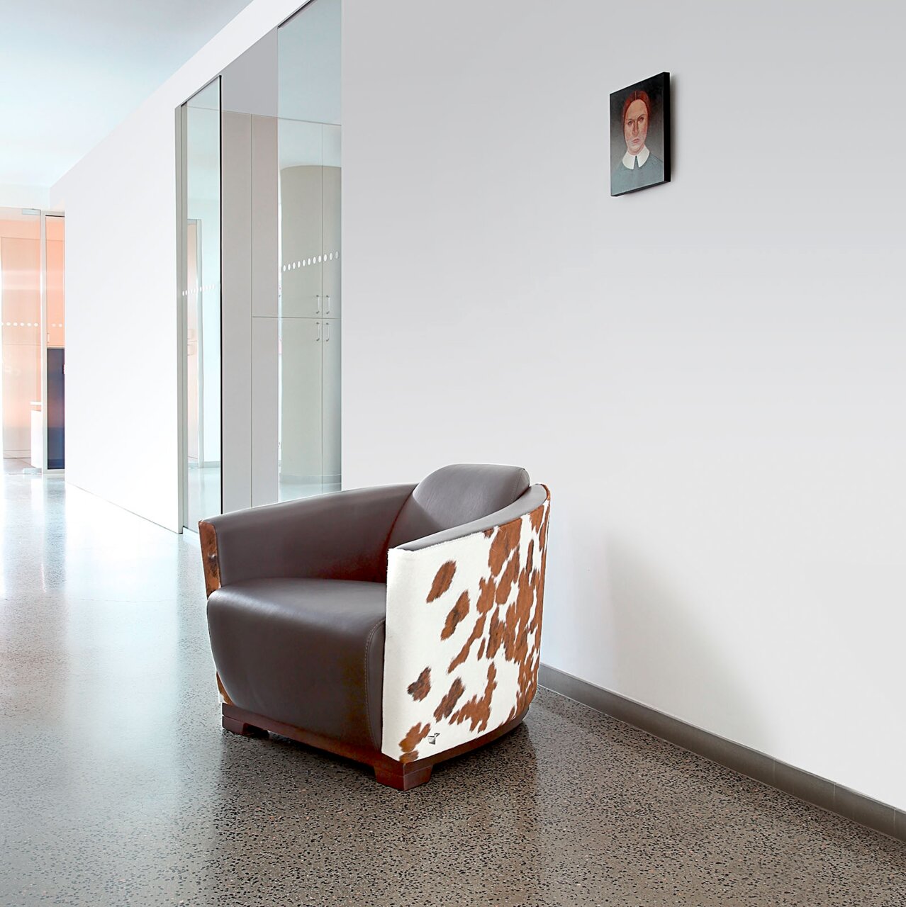 Moderner Sessel mit braunem Leder und Kuhfellmuster, seitliche Perspektive