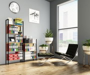 Modernes Homeoffice mit schwarzem Lounge-Sessel und Hocker vor großen weißen Jalousien, daneben Regal mit Ordnern und Pflanzen; Perspektive: leicht schräg von vorne auf die Raumecke