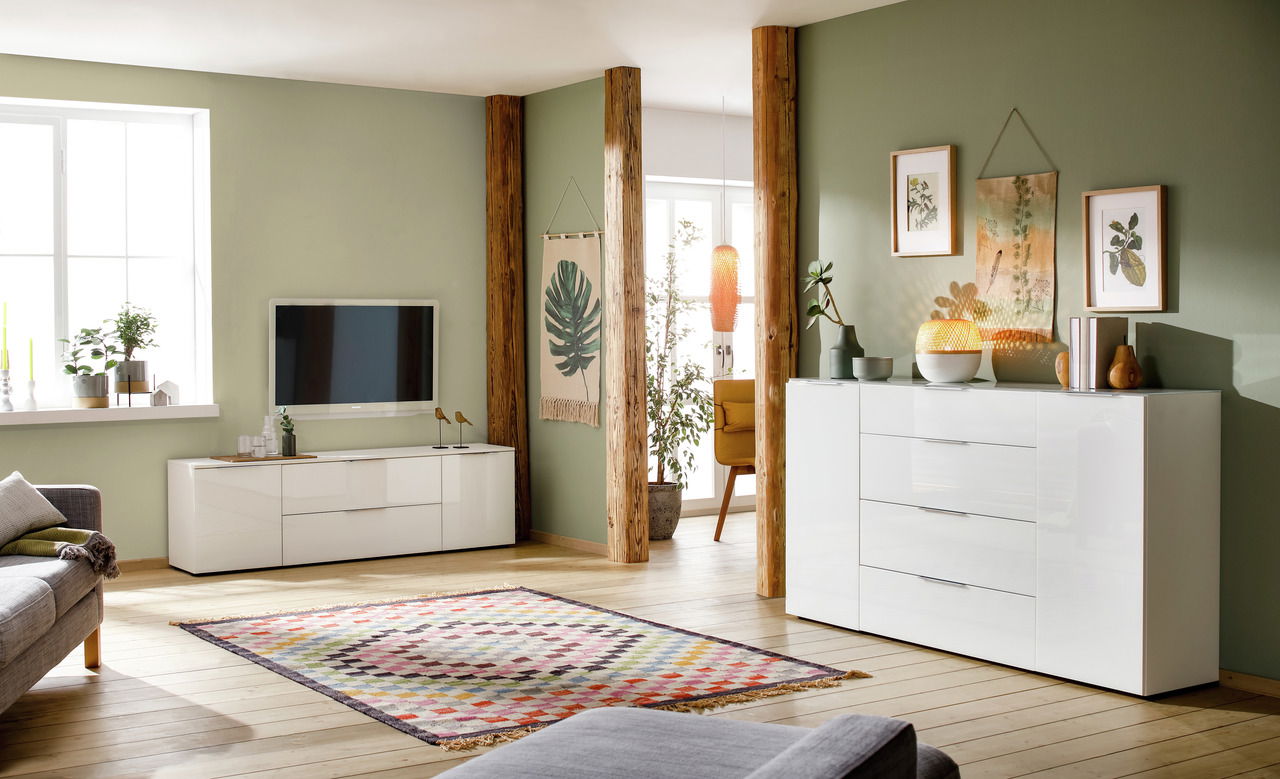 Modernes Wohnzimmer mit weißem Hochglanz-Sideboard und TV-Lowboard, seitliche Perspektive