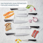 Vogelperspektive auf einen 7-teiligen Messerblock mit verschiedenen Messern und Zutaten auf einer Marmoroberfläche.