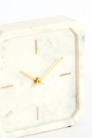 Elegante Tischuhr aus weißem Marmor mit goldenen Zeigern und minimalistischen Markierungen, seitliche Perspektive
