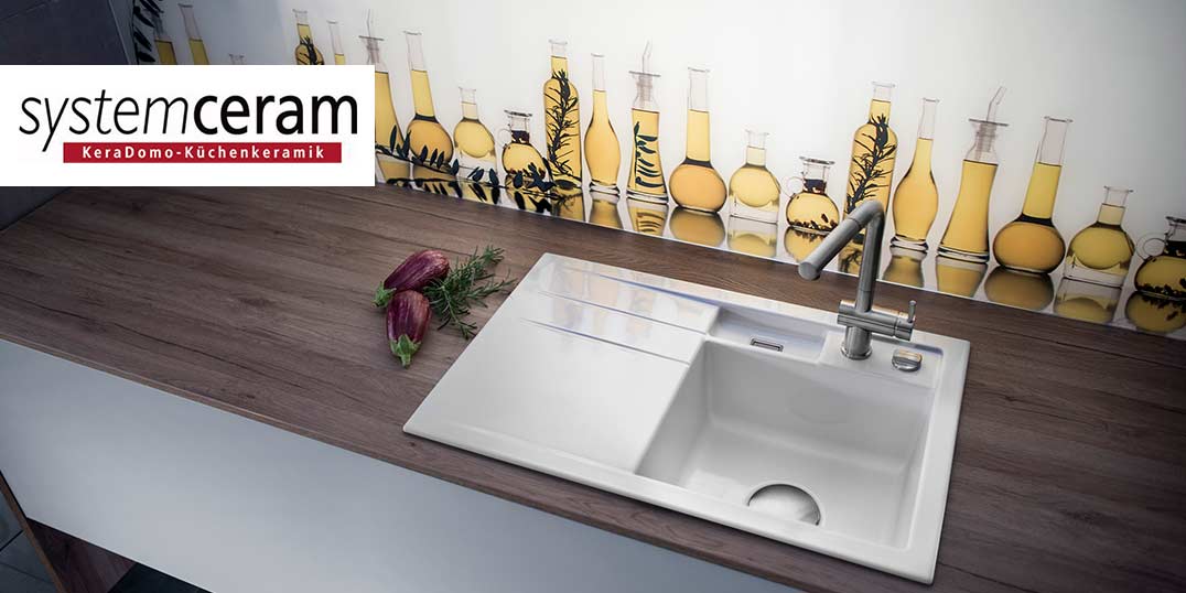 weiße Keramikspüle mit Armatur auf Holzarbeitsplatte.