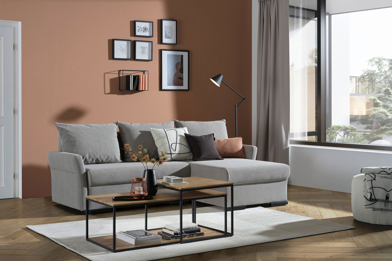 Ti´me Ecksofa DAX Graue Rundecke (L) in einem modernen Wohnzimmer mit Holzboden, dekoriert mit Kissen und einem Couchtisch, seitliche Perspektive.