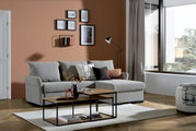 Graue Rundecke (L) in einem modernen Wohnzimmer mit Holzboden, dekoriert mit Kissen und einem Couchtisch, seitliche Perspektive.