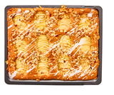 Vogelperspektive auf ein Backblech mit einem Apfelkuchen, dekoriert mit Mandelsplittern und Zuckerguss.