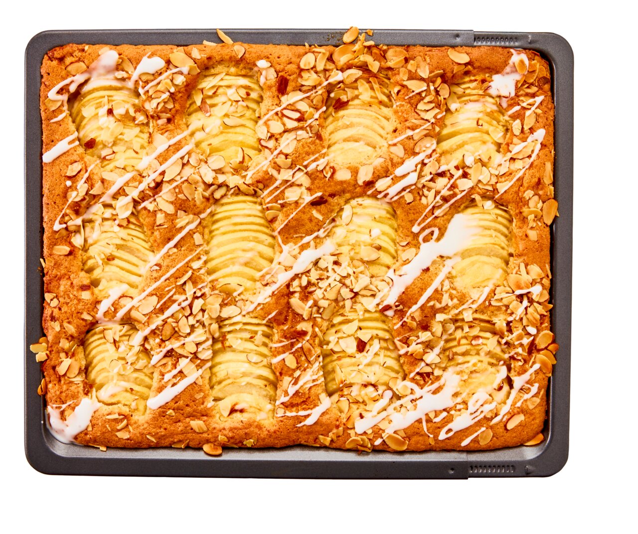Vogelperspektive auf ein Backblech mit einem Apfelkuchen, dekoriert mit Mandelsplittern und Zuckerguss.