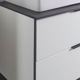 Nahaufnahme eines modernen Waschtisch-Sets mit weißem Schrank und dunkler Arbeitsplatte, seitliche Perspektive