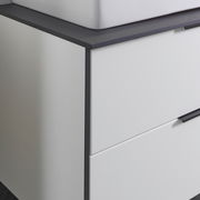 Nahaufnahme eines modernen Waschtisch-Sets mit weißem Schrank und dunkler Arbeitsplatte, seitliche Perspektive
