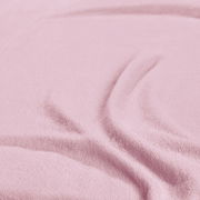 Nahaufnahme eines rosa Spannbetttuchs mit weicher Textur und Falten.
